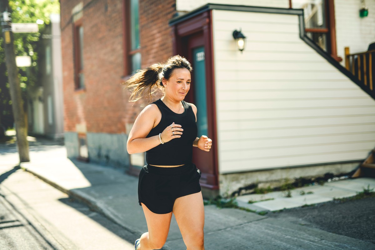 Woman in shorts running on a city street.