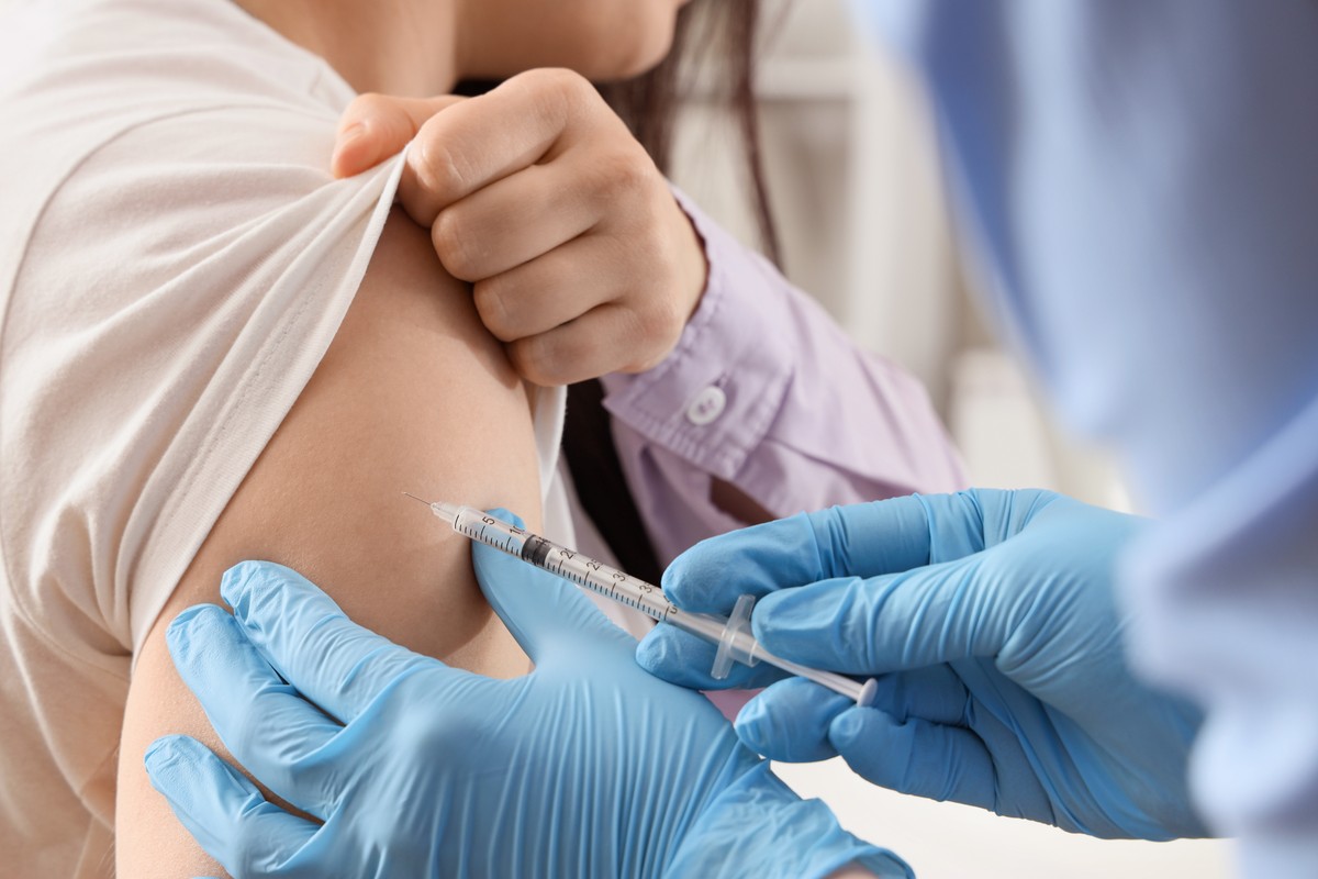 Nurse administering a vaccine to patient's arm.