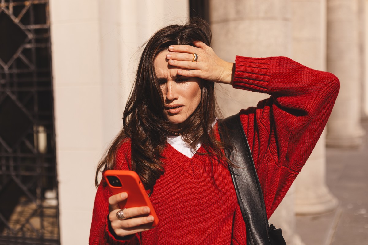Woman with her hand on her head, appearing to be in deep thought or distress.