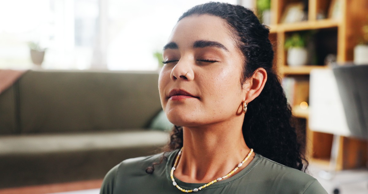 Woman in a meditative pose with her eyes closed.