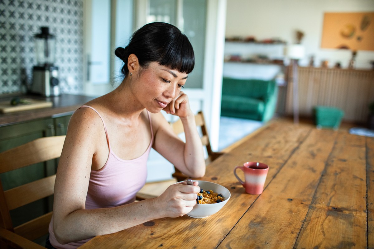A woman eating food at a table.