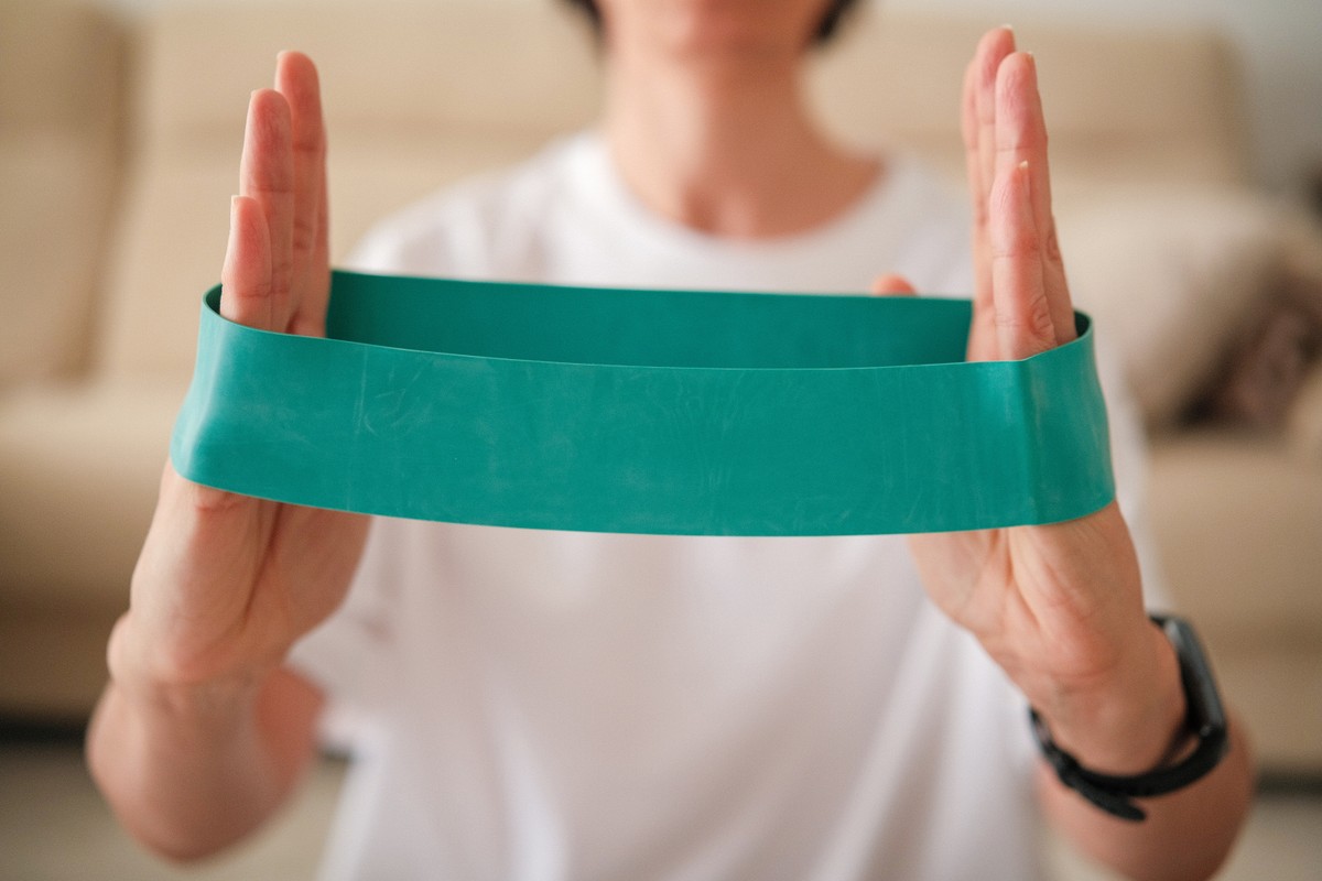 Hand holding a blue exercise resistance band