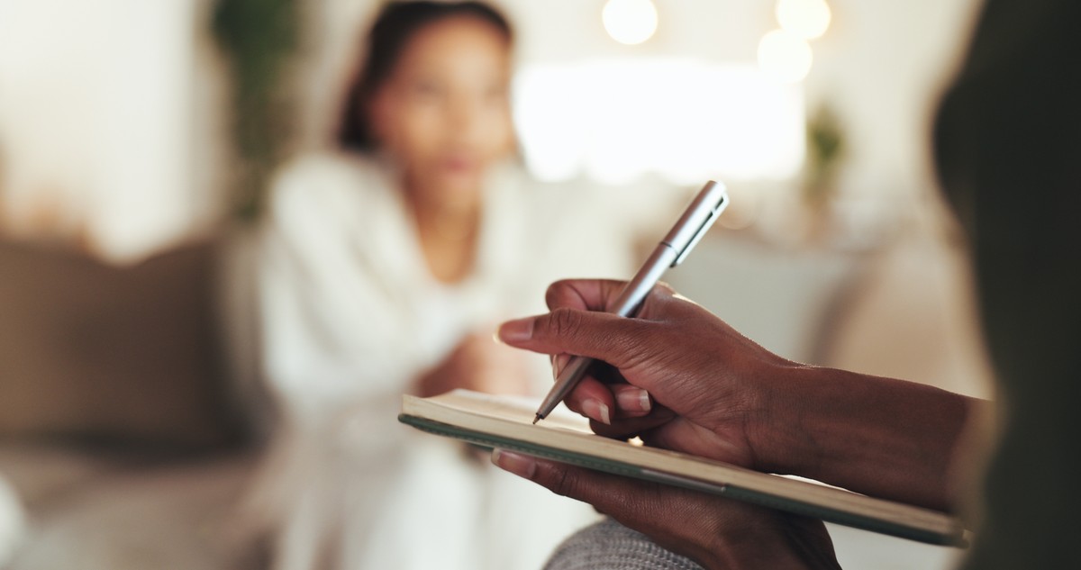 Person sitting and writing in a notebook.