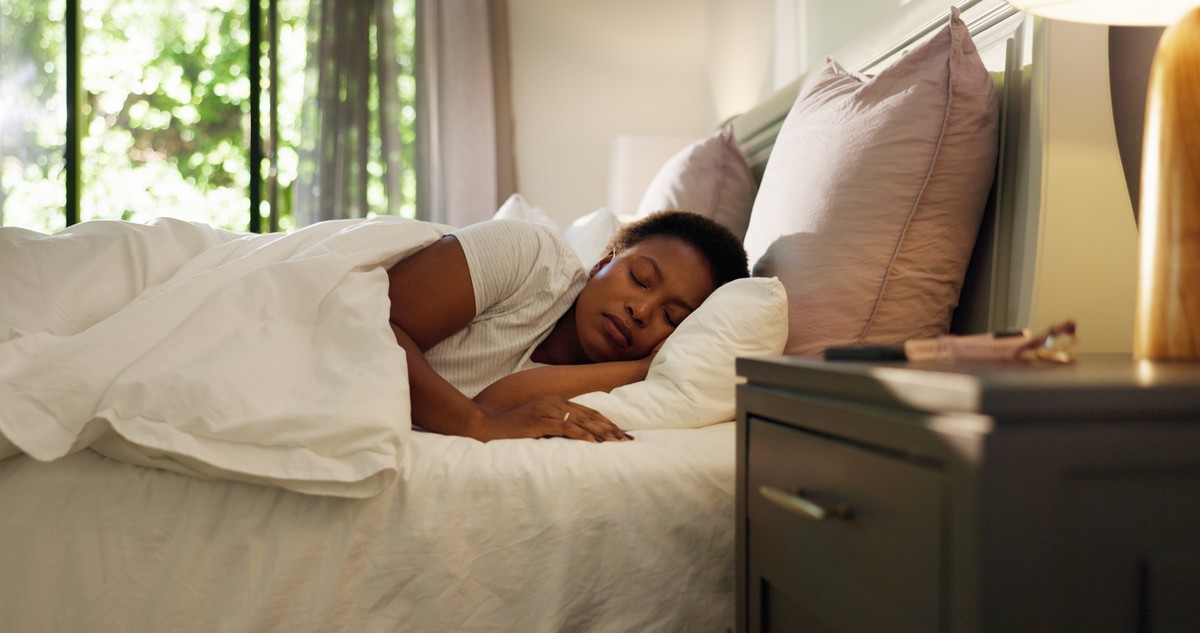 Woman asleep on a bed with pillows.