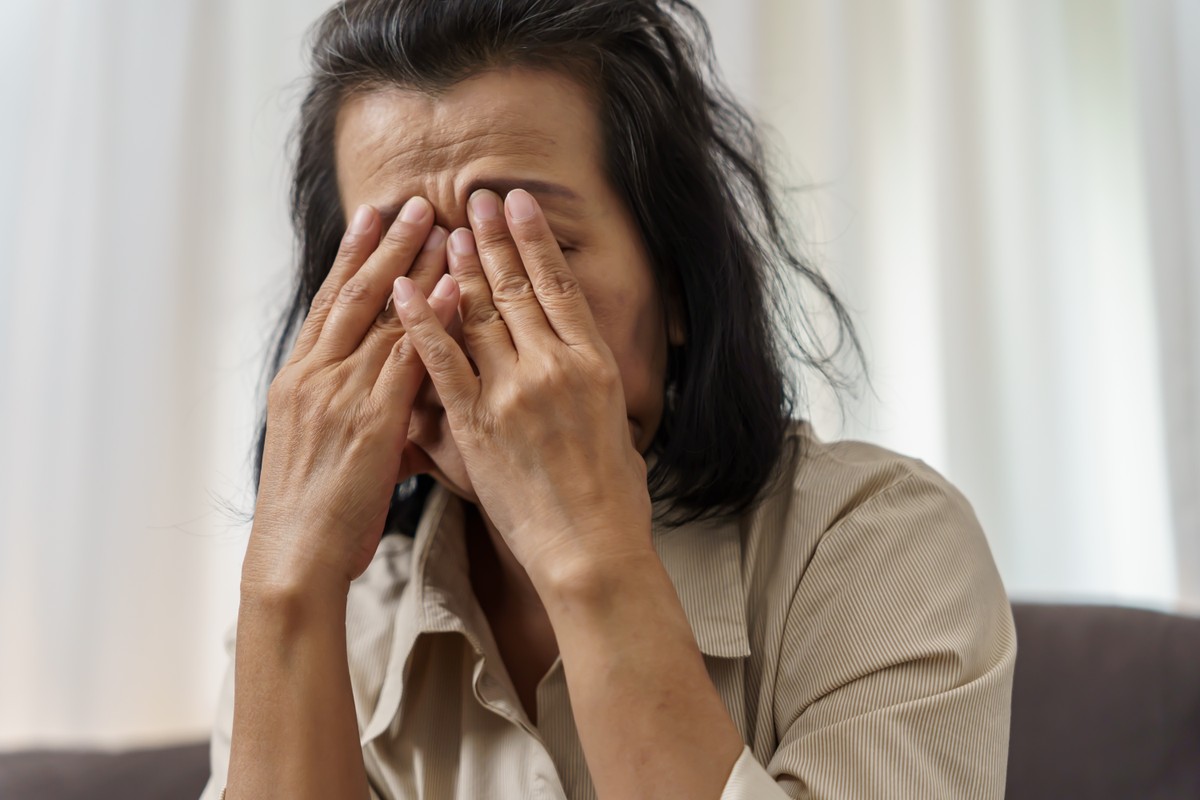 A woman covering her face with her hands, expressing shock or surprise.