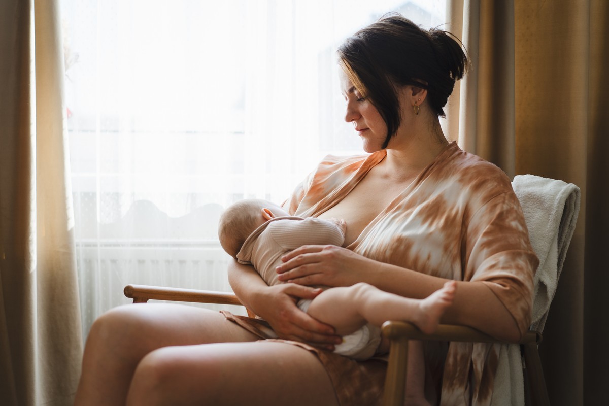 Mother nursing her baby in a lounge setting.