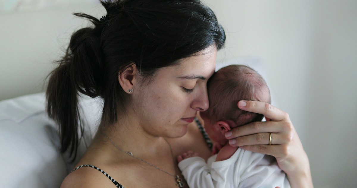 Nurse gently holding a newborn baby.