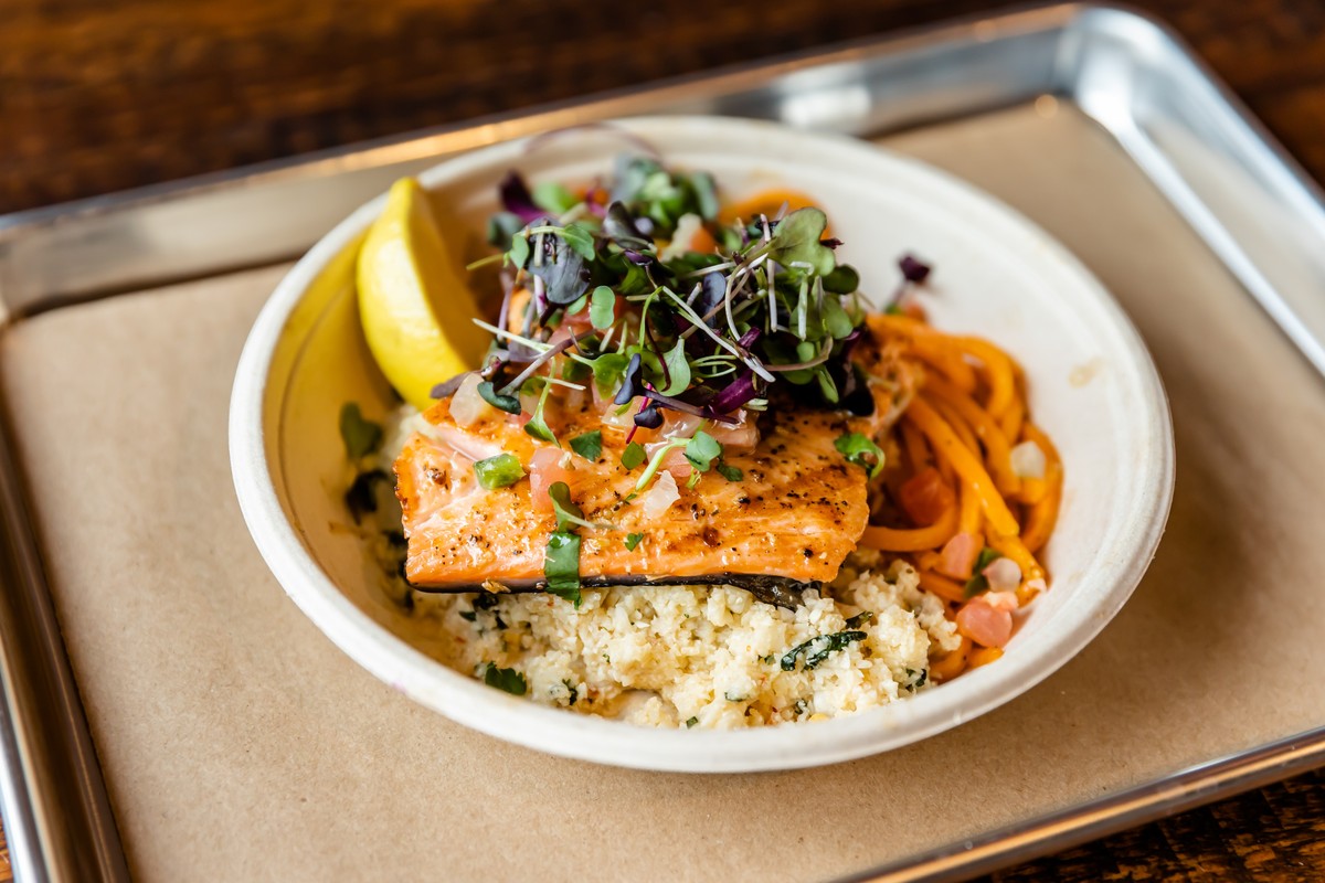 Salmon and veggie bowl on a table.